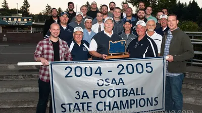 Group photo with the 2004-2005 OSAA 3A Football State Champions banner at Randall Stadium