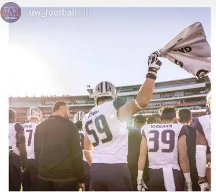 Draco Bynum, Washington No. 59, waving a towel with teammates on the field at the Rose Bowl