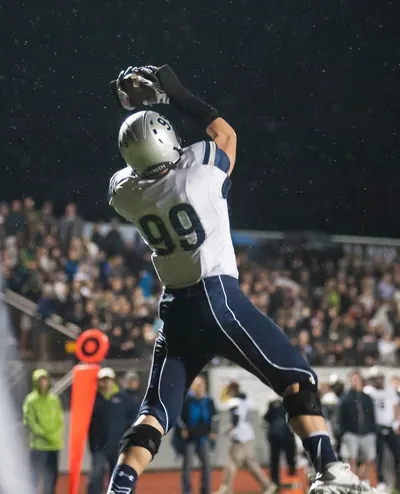 Draco Bynum, Wilsonville No. 99, making a leaping touchdown catch in the end zone in the rain during Wilsonville's 24-21 comeback win at Liberty in the 2015 OSAA 5A state quarterfinals (Nov 13, 2015)