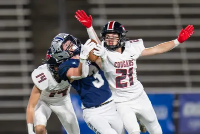 Nick Crowley, Wilsonville No. 3 in a navy jersey, catching the ball between Mountain View defenders No. 14 and No. 21 in the 2023 5A state championship game