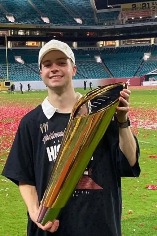 Anders Ericson holding the CFP National Championship Trophy for Alabama's 2020 season title
