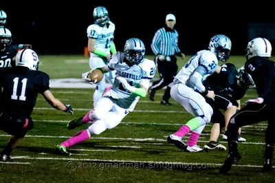 Tanner Shipley, No. 21 in a white Wilsonville away jersey, cutting upfield with the ball past defenders in black at a night game, 2012